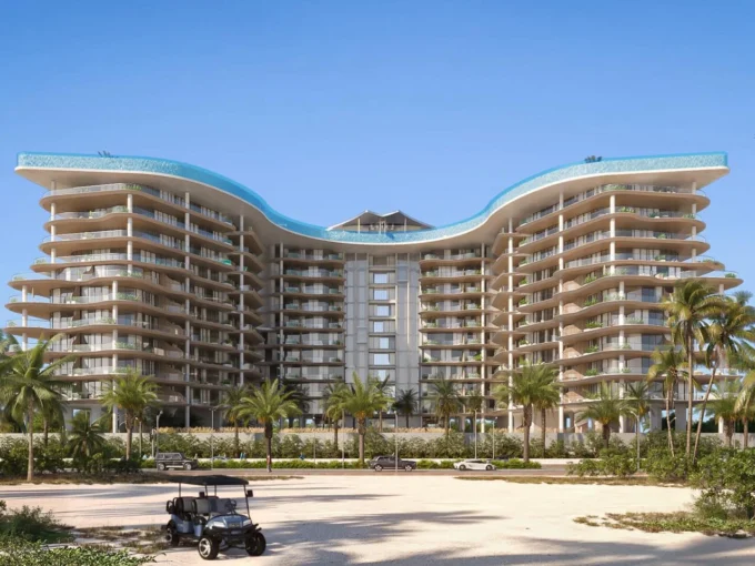 A striking, multi-story Manta Bay resort building with a curved, wave-like roof and rooftop pools.