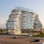 A modern, curved glass building, "Acacia by BNW Developments," rises beside a road with palm trees.
