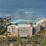 Aerial view of Address Residences showing beachfront towers, lush greenery, and private coastline.