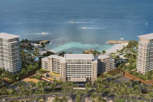 Aerial view of Address Residences showing beachfront towers, lush greenery, and private coastline.