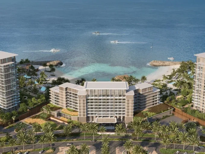 Aerial view of Address Residences showing beachfront towers, lush greenery, and private coastline.
