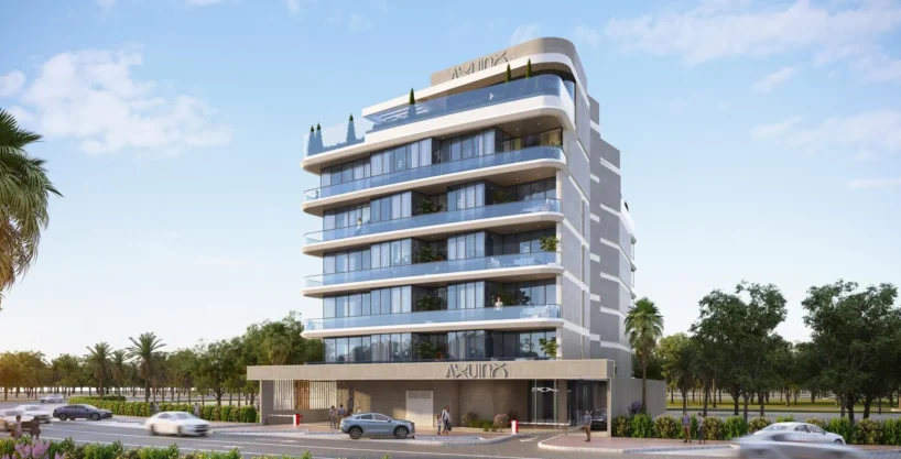 A modern, multi-story building, "Aquino by BNW Developments", with glass balconies, on a sunny street.