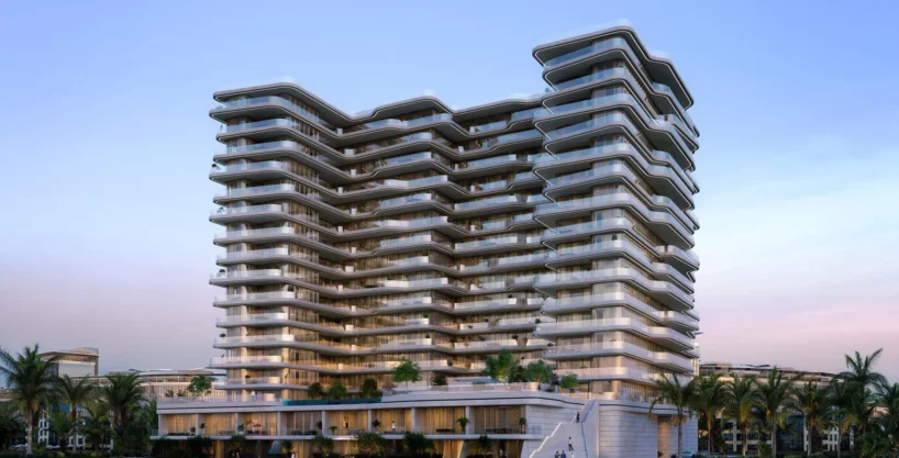 Modern beachfront tower with curved glass balconies, showcasing Aston Martin Residences at sunset.