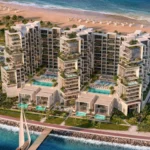 Aerial view of Masa Residences showing beachfront towers, pools, and villas along the coast.
