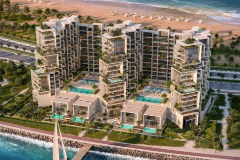 Aerial view of Masa Residences showing beachfront towers, pools, and villas along the coast.