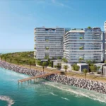 A high-angle shot captures three modern, white Moonstone buildings along a rocky coast.