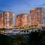 Night view of Nobu Residences towers glowing with warm lights near the beach on Al Marjan Island.