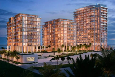 Night view of Nobu Residences towers glowing with warm lights near the beach on Al Marjan Island.
