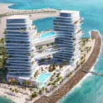Aerial view of Oceano, a twin-tower resort with pools, balconies, and a beach.