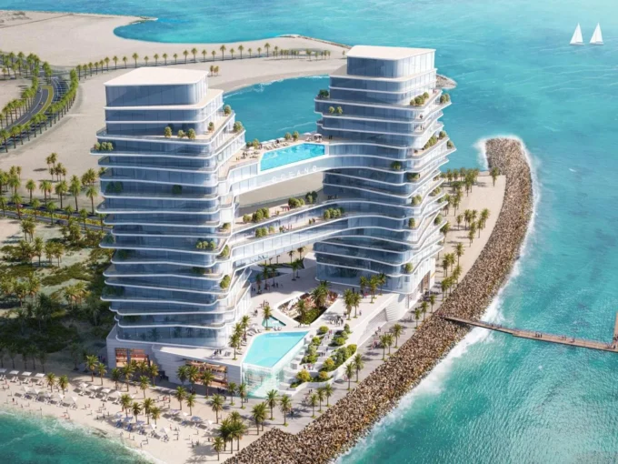 Aerial view of Oceano, a twin-tower resort with pools, balconies, and a beach.