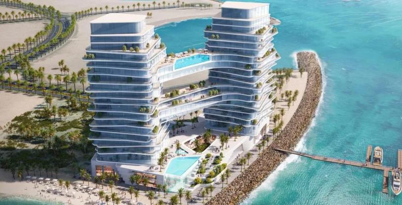 Aerial view of Oceano, a twin-tower resort with pools, balconies, and a beach.