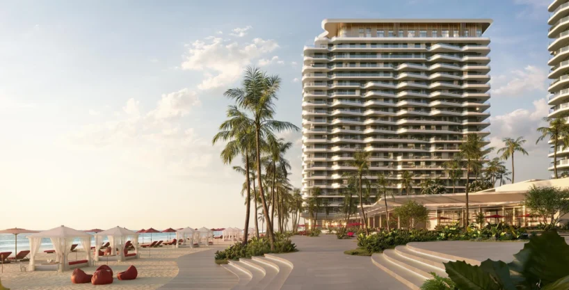 Rosso Bay Residences, a tall building on a sunny beach with palm trees and cabanas.